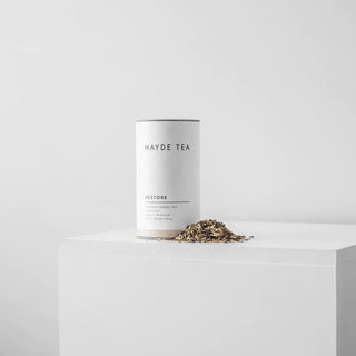 Mayde Tea Restore canister with loose tea on a white surface and background