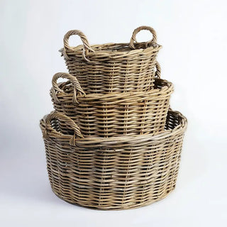 Set of three woven baskets of different sizes on a white background