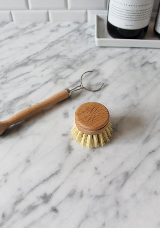 Wooden dish brush and scrubber on a marble surface
