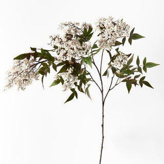 Artificial flower branch with white flowers and green leaves on a white background