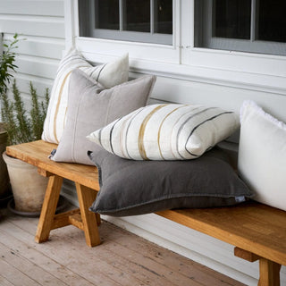 Wooden bench with decorative pillows on a wooden deck