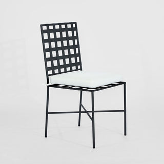 Black metal chair with a grid back design on a light gray background
