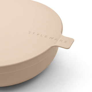 Beige bowl with a handle on a light gray background, featuring 'STYLEWARE' branding.