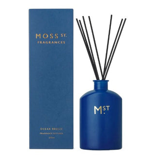 Blue fragrance diffuser with sticks and packaging labeled 'Moss St. Fragrances' on a white background.