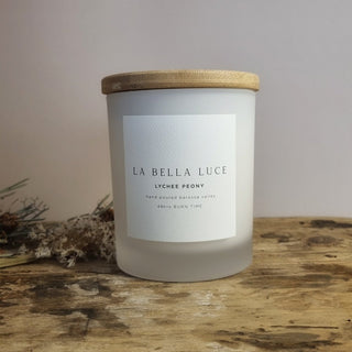 Frosted candle with wooden lid on a wooden surface