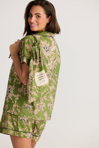 Woman wearing a green floral dress with a white background