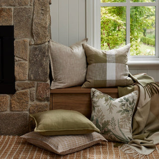 Cozy living room corner with stone fireplace, wooden bench, and decorative pillows.