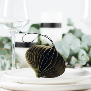 Decorative green leaf-shaped object on a white plate with a blurred background