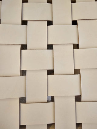 Close-up of a woven leather tile pattern with beige tiles