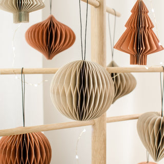 Hanging paper decorations in various shapes and colors on a wooden rack.