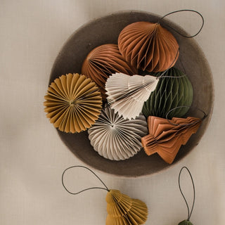 Decorative paper ornaments in earthy tones on a textured surface