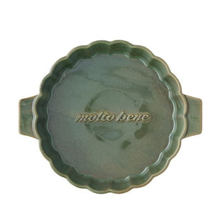 Green ceramic dish with scalloped edge and 'molto bene' text on a white background