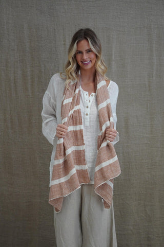 Woman wearing a striped scarf against a plain background