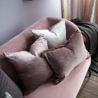 Pink sofa with decorative pillows in a cozy room setting