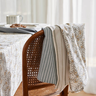 Dining table with a floral-patterned tablecloth, chair, and a plate of food.