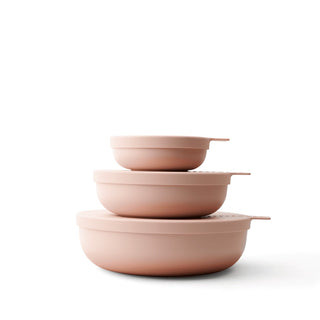 Set of three pink bowls stacked on a white background