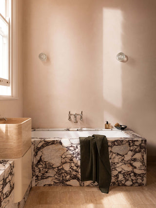 Bathroom with marble bathtub and wooden sink