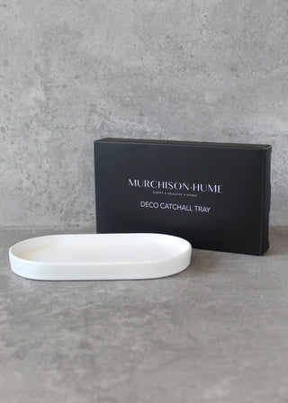 White decorative catchall tray with Murchison-Hume packaging on a gray surface