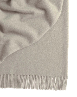 Close-up of a light gray scarf with fringed edge on a white background