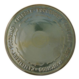 Round metal cheese press with embossed text on a white background