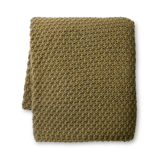 Folded green knitted blanket on a white background