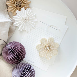 Decorative paper flowers and balls on a textured surface