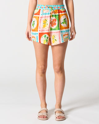 Person wearing colorful shorts with a pattern of tea boxes on a white background