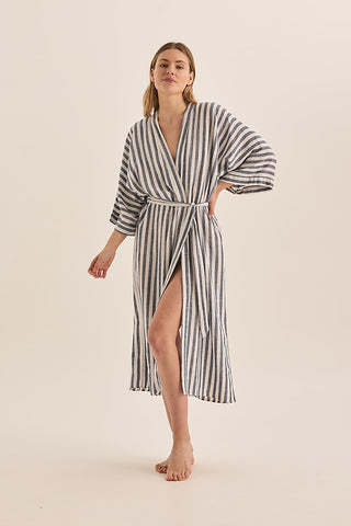 Woman wearing a striped robe on a beige background