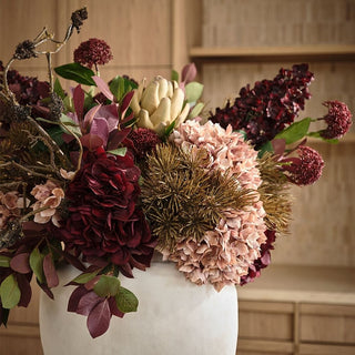Bouquet of flowers in a white vase with a neutral background