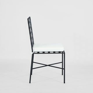 Black metal chair with white cushion on a light gray background