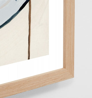 Close-up of a wooden picture frame with a white mat and beige wall background